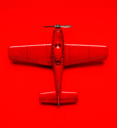 Vintage red airplane model metal toy  over a red background