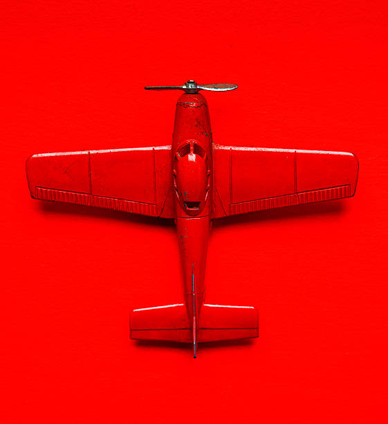 Model toy vintage airplane Vintage red airplane model metal toy  over a red background toy airplane stock pictures, royalty-free photos & images