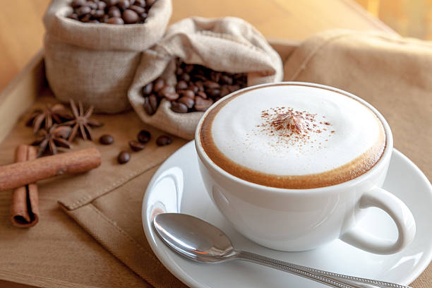 cappuccino with coffee beans A cup of cappuccino with coffee beans frothy drink stock pictures, royalty-free photos & images