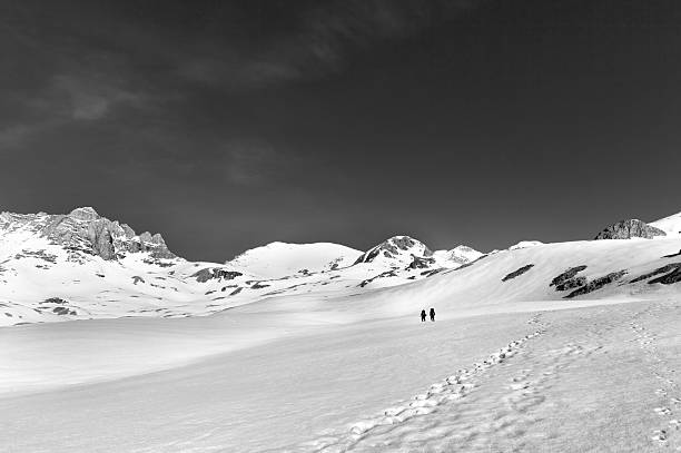 istock Two hikers on snow plateau (black and white) 523169492