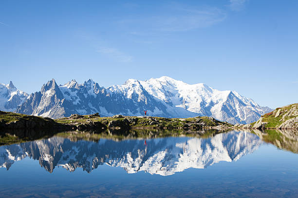 Lone traveler hikes near Lac Blanc in Chamonix A lone male hiker hiking at Lac Blanc near Chamonix sticks his hands in the air with excitement as he reached the beautiful clear lake mont blanc massif stock pictures, royalty-free photos & images