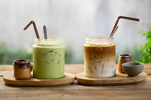 Green tea and iced coffee on wood table. Delicious of green tea and iced coffee in glass cup on wood table. and homemade cookies tea with milk stock pictures, royalty-free photos & images