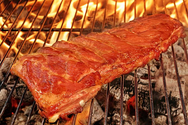 cerdo o chuletas de cerdo cerdo a la barbacoa a la parrilla con llamas - rubbing spice rib barbecue fotografías e imágenes de stock