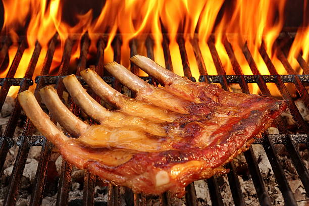 wieprzowina powrót dziecka lub żeberek na bbq grill z płomieni - rubbing spice rib barbecue zdjęcia i obrazy z banku zdjęć