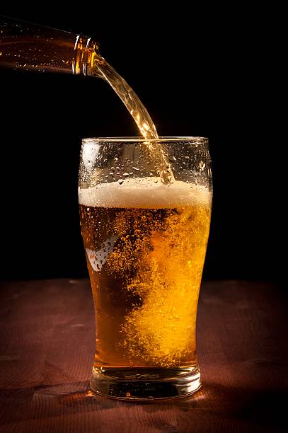 istock fresh beer pouring from bottle into glass 523176492