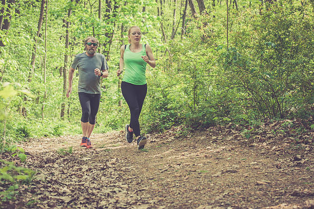 istock Young woman and elderly man running in the forest 523178486