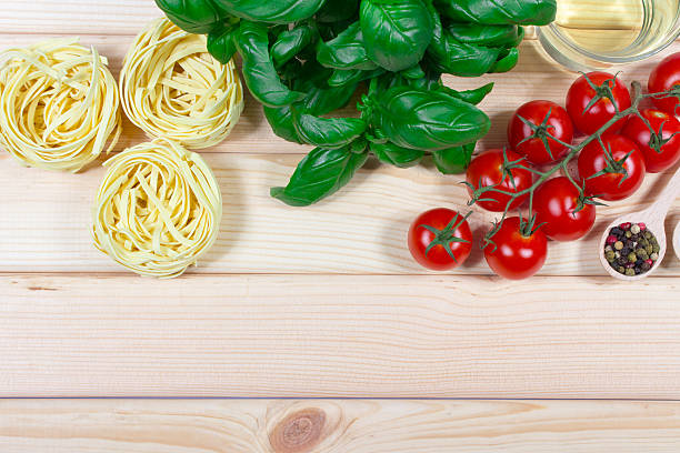 Raw homemade pasta and ingredients for pasta with tomatoes, basil.