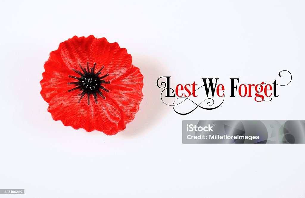 Lest We Forget Red Poppy Lapel Pin Badge Lest We Forget, Red Flanders Poppy Lapel Pin Badge for November 11, Remembrance Day appeal. on white background with Lest We Forget sample text. Remembrance Day Stock Photo