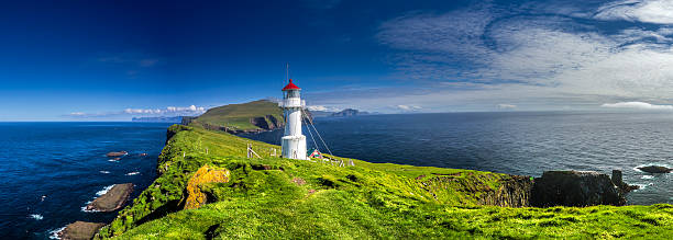 Lighthouse on Mykines, Faroe islands Panoramic view of Old lighthouse on the beautiful island Mykines. faroe islands photos stock pictures, royalty-free photos & images