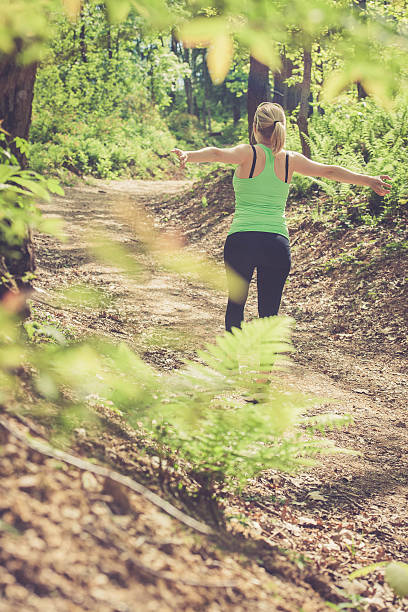 istock Young blonde womanwalking with arms raised 523181746