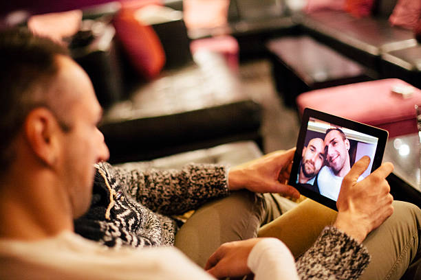 istock handsome gay couple view their selfies on a digital tablet 523182849