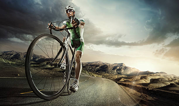 Sport. Road cyclist. Professional male cyclist riding on racing bike on road through mountains under dramatic stormy sky at sunset racing bicycle photos stock pictures, royalty-free photos & images