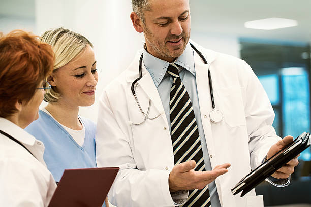 istock doctor show data on tablet pc to his collegues 523201675