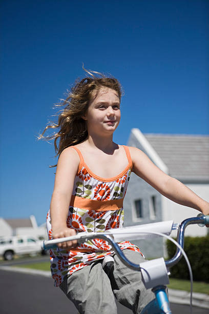 девочка верхом велосипед на улице - summerwear стоковые фото и изображения