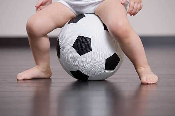 istock Baby Sitting On Soccer Ball 523203471