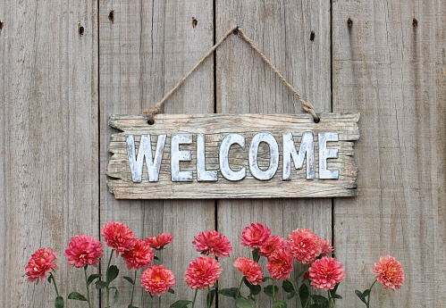 Wood welcome sign with autumn flower border by wooden background