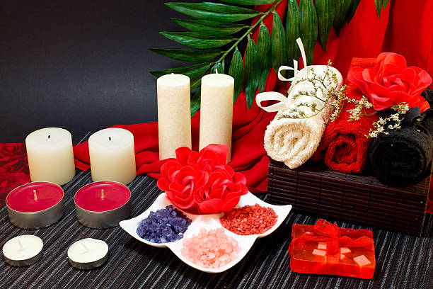 composition de spa en rouge et noir avec des serviettes de couleurs - alternative therapy aromatherapy spa treatment candle photos et images de collection