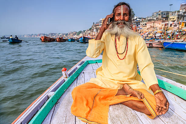 istock Sadhu using mobile in boat on Holy Ganges River, Varanasi 523242340