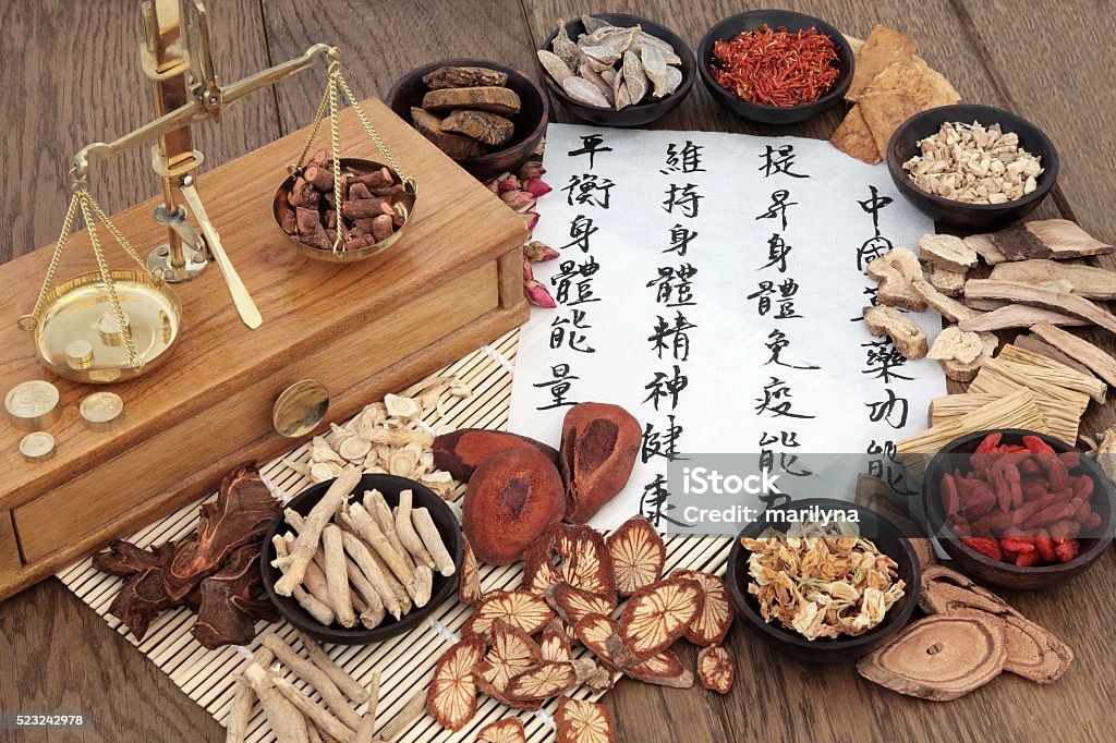 Chinese Apothecary Herbs Chinese herbal medicine with herb ingredients, scales and calligraphy on rice paper. Translation reads as chinese herbal medicine as increasing the bodys ability to maintain body and spirit health and balance energy. Chinese Herbal Medicine Stock Photo