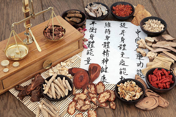 Chinese Apothecary Herbs Chinese herbal medicine with herb ingredients, scales and calligraphy on rice paper. Translation reads as chinese herbal medicine as increasing the bodys ability to maintain body and spirit health and balance energy. chinese script photos stock pictures, royalty-free photos & images