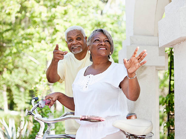 senior pareja afroamericana ciclismo de bicicletas - action mature adult bicycle senior couple fotografías e imágenes de stock