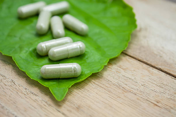 istock herbal medicine capsules with green herb leaf on wood table 523246678