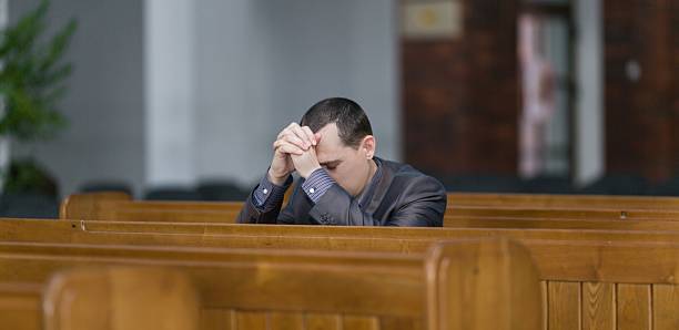 homem rezar na igreja - confession booth imagens e fotografias de stock
