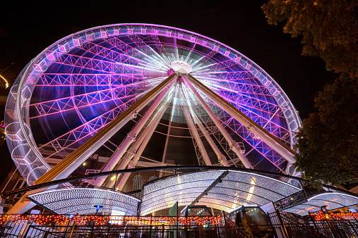 Red tone illuminated colorful illuminated ferris wheel at night