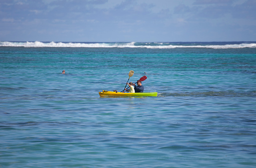 Rarotonga, Cook Islands - February 5, 2009: Father and son sea kayaking in the lagoon of Rarotonga, Cook Islands. Rarotonga is surrounded by a lagoon, which often extends more than a hundred yards to the reef, then slopes steeply to deep water.