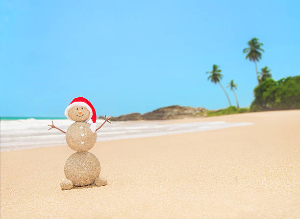 istock Christmas sandy snowman in santa hat at tropical beach 523261043