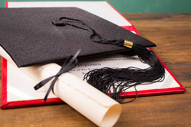 istock Graduation!  Cap, motarboard and tassel with dilplomas on table. Education. 523261634