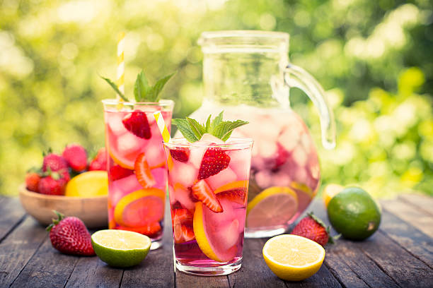 Pink lemonade with lemon, lime and strawberries Pink lemonade with lemon, lime and strawberries  refreshment stock pictures, royalty-free photos & images