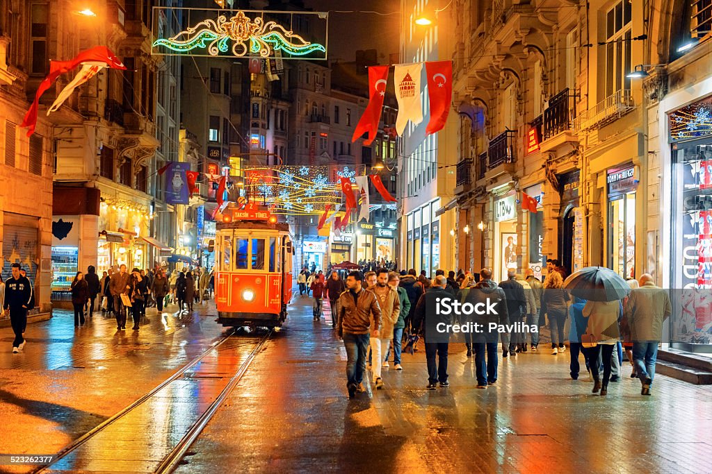 Christmas Lights, National Flags and Tramway in Istanbul, Turkey Illuminated Tramway on a rainy Istiklal Avenue (Independence Avenue), Lots of national flags for the Republic Day. iStockalypse. Nikon D3x Istiklal Avenue Stock Photo