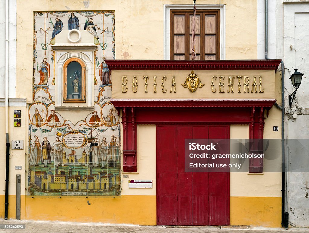 Pharmacy Xativa , Spain - September 27, 2014: The central pharmacy in Xativa, province Valencia, Spain. On the wall an 18th century rococo Christian ceramic mural and a shrine. Pharmacy Stock Photo