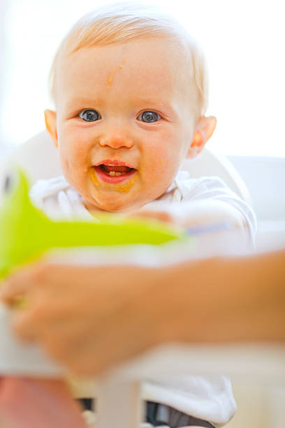 istock Eat smeared smiling baby sitting in chair 523263743
