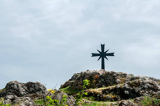 istock Christian cross on rocky hill 523264012