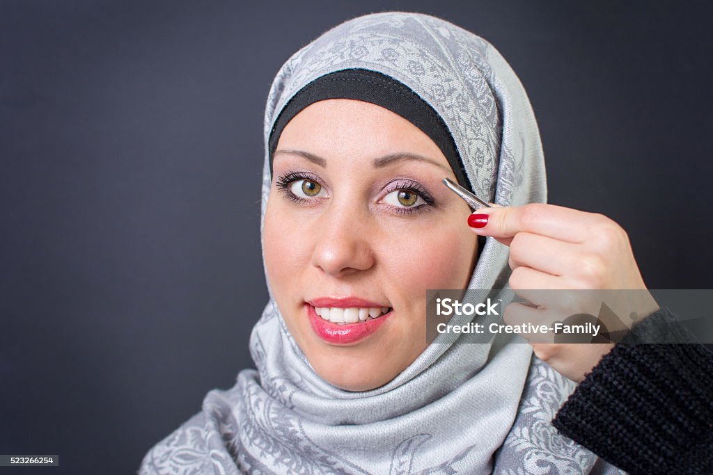 Muslim woman plucking eyebrows Beautiful muslim woman plucking eyebrows Islam Stock Photo