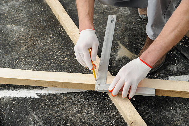 istock Worker measures off a wooden beam. 523266720