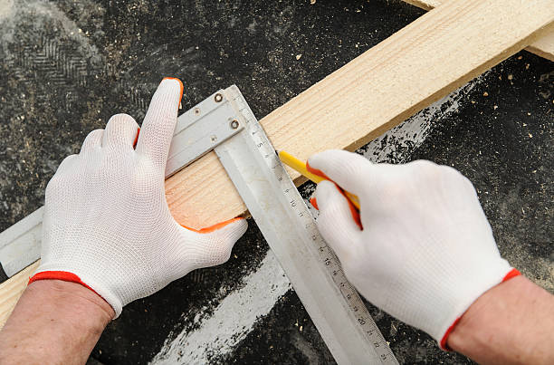 istock Worker measures off a wooden beam. 523268136