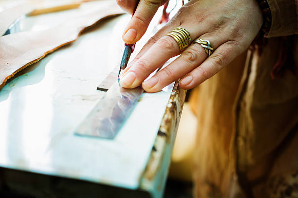 istock Close-up on a female leather worker's hands cutting a band 523274519