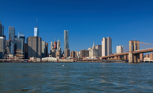 Wide angle view of Manhattan Lower East Side as seen from the Brooklyn Bridge Park on a beautiful autumn day, New York City. The World Trade Center tower is on the left, Beekman Tower is in the middle and the Brooklyn Bridge is on the right.