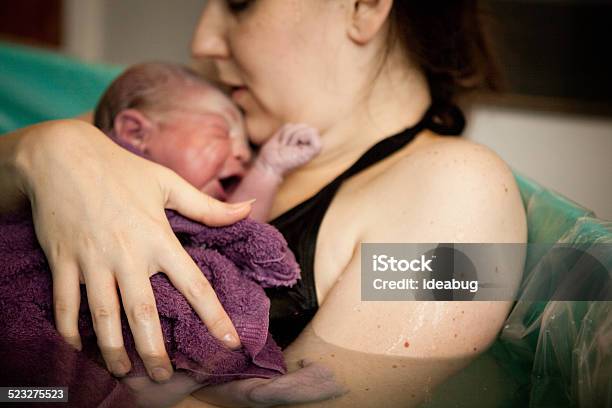 Mother Holding Newborn In Birthing Tub After Home Water Birth Stock Photo - Download Image Now