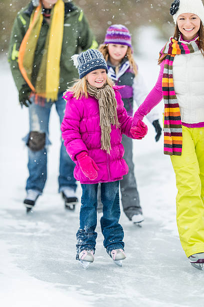 familiale patin à glace sur l'étang - ice skating young couple daughter mother photos et images de collection