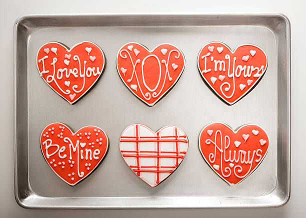 en forme de cœur sur le plateau de cuisson cookies - valentines day nobody plaque studio shot photos et images de collection