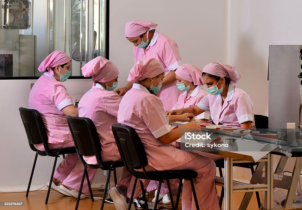 Woman packing products in the pharmaceutical factory in Birth Control Pill Stock Photo