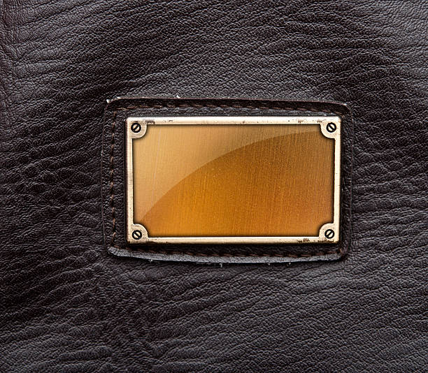 istock glass plate in metal label on old black leather background 523277219