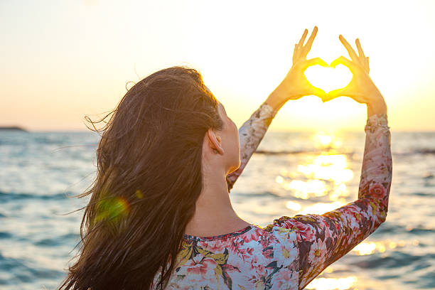 istock handsome girl making heart round the sun 523277449