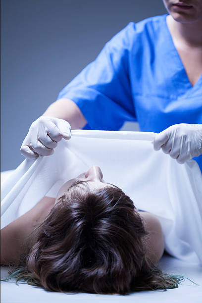 Worker of mortuary covering the dead body Worker of mortuary covering the dead body of woman morgue stock pictures, royalty-free photos & images