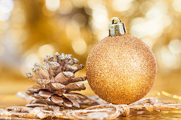 istock Closeup on decorations: golden christmas ball and cone 523287781
