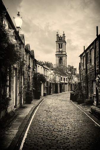 St Stephen's church in the distance, beyond a narrow cobbled mews street in Stockbridge, Edinburgh.